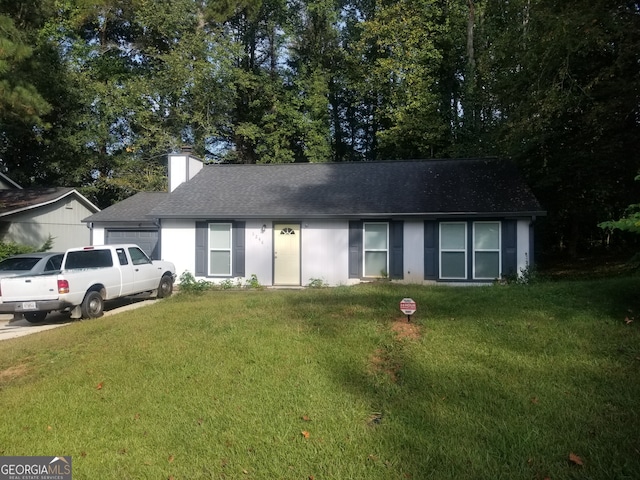 ranch-style home with an attached garage, a chimney, a front yard, and roof with shingles
