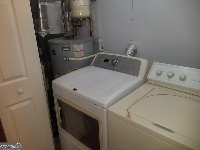 clothes washing area featuring washer and dryer and water heater