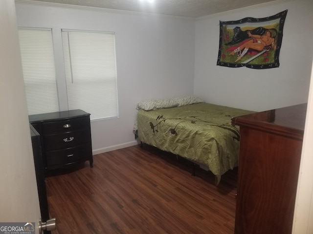 bedroom featuring wood finished floors, ornamental molding, and baseboards