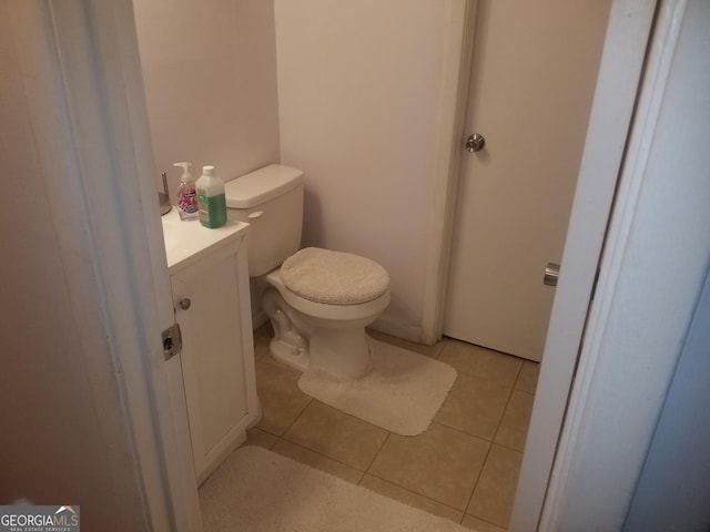 bathroom featuring tile patterned flooring, toilet, and vanity