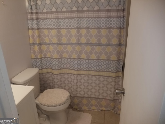 bathroom with toilet, vanity, tile patterned flooring, and a shower with shower curtain