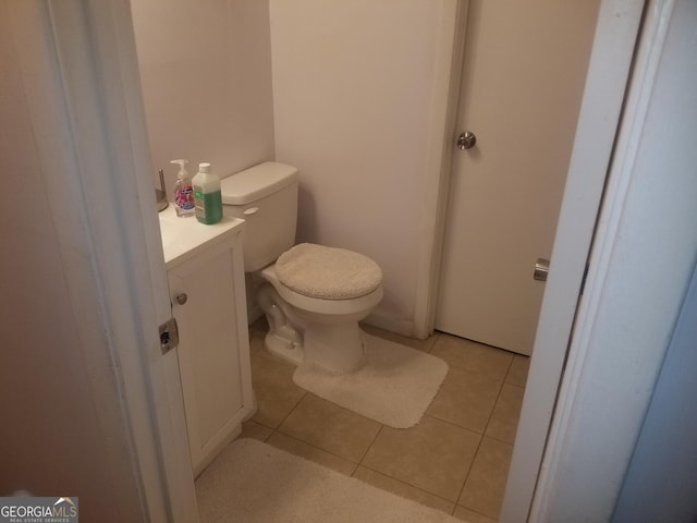 bathroom with tile patterned flooring, vanity, and toilet