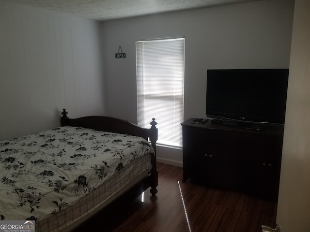 bedroom featuring wood finished floors and baseboards