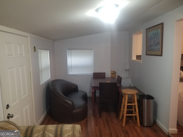 living area with wood finished floors, baseboards, and vaulted ceiling