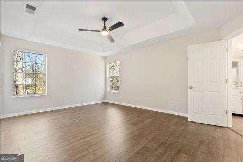 unfurnished room with dark hardwood / wood-style floors and ceiling fan