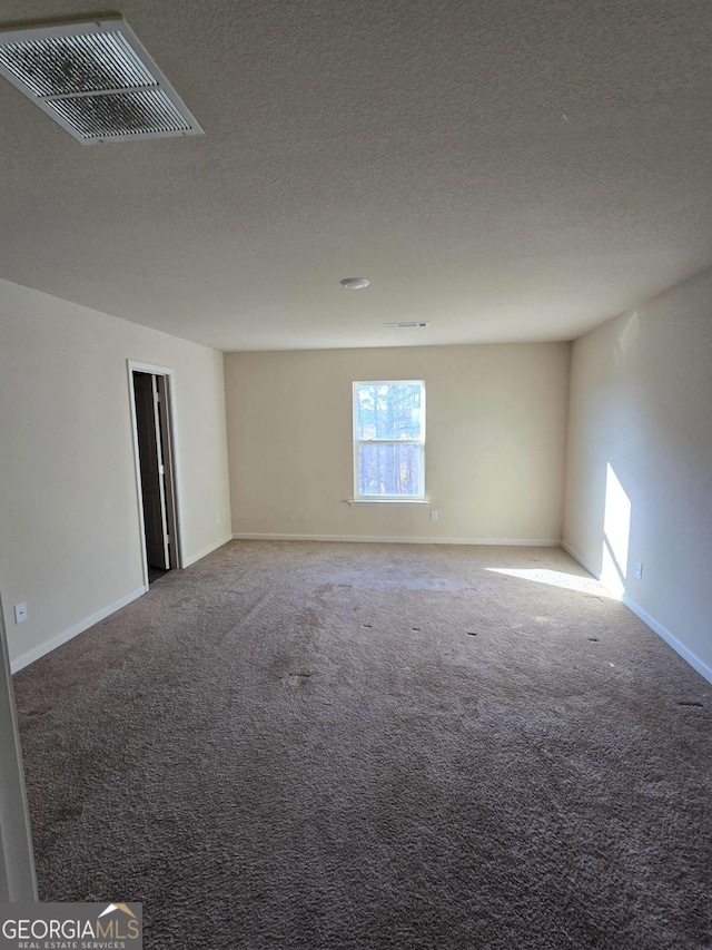 carpeted spare room featuring a textured ceiling