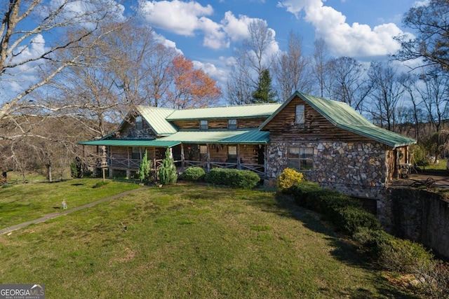 log-style house with a porch and a front lawn