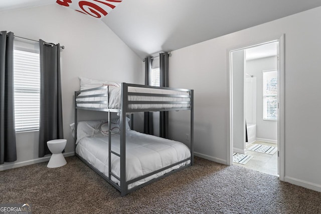 carpeted bedroom featuring ensuite bathroom and lofted ceiling