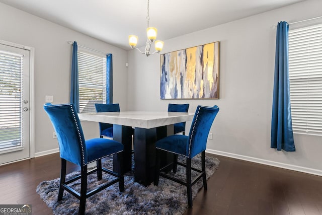 dining area featuring a healthy amount of sunlight, a chandelier, and dark hardwood / wood-style floors