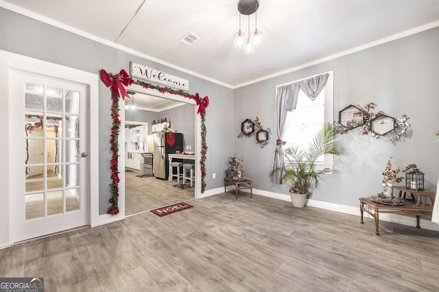 interior space with hardwood / wood-style floors and ornamental molding