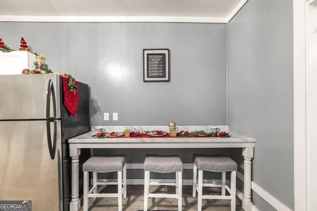 kitchen with a kitchen bar and stainless steel refrigerator