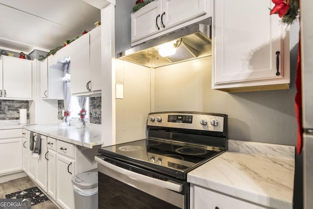 kitchen featuring white cabinets, light stone countertops, light wood-type flooring, and electric stove