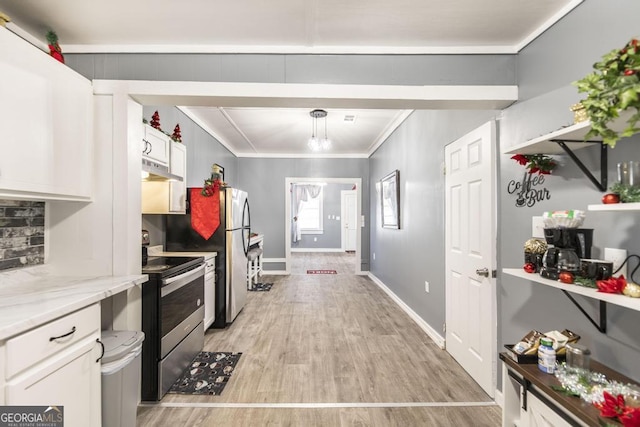 kitchen featuring appliances with stainless steel finishes, light stone counters, decorative light fixtures, light hardwood / wood-style flooring, and white cabinetry