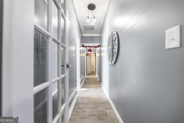 hall featuring ornamental molding and light hardwood / wood-style flooring