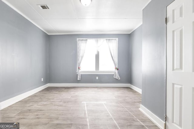 unfurnished room featuring light wood-type flooring and crown molding