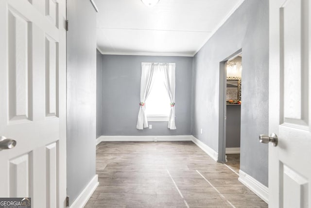 empty room with hardwood / wood-style flooring and crown molding