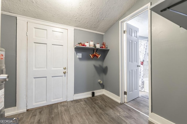 clothes washing area featuring a textured ceiling and dark wood-type flooring