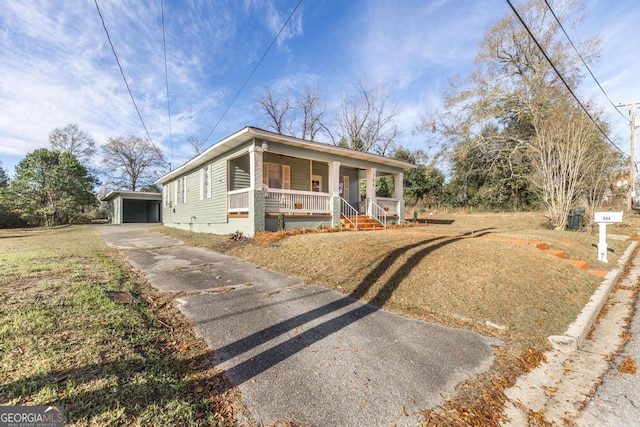 bungalow-style house with a front yard, covered porch, an outdoor structure, and a garage