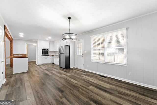 unfurnished living room featuring a notable chandelier, dark hardwood / wood-style flooring, and crown molding