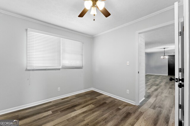 spare room with ornamental molding, a textured ceiling, ceiling fan, and dark wood-type flooring