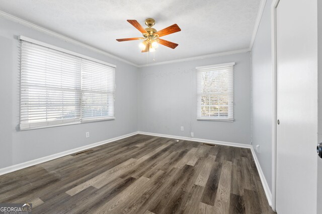 empty room featuring ceiling fan, dark hardwood / wood-style flooring, and ornamental molding