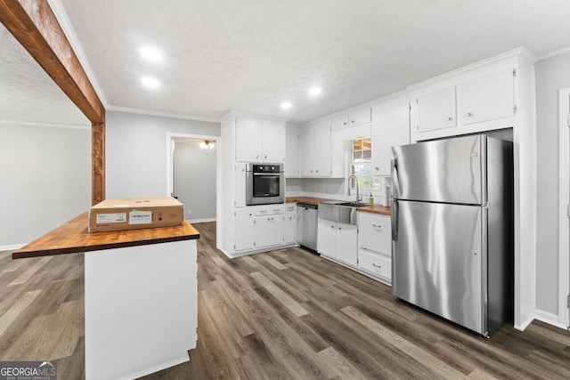 kitchen featuring butcher block countertops, white cabinetry, sink, and appliances with stainless steel finishes