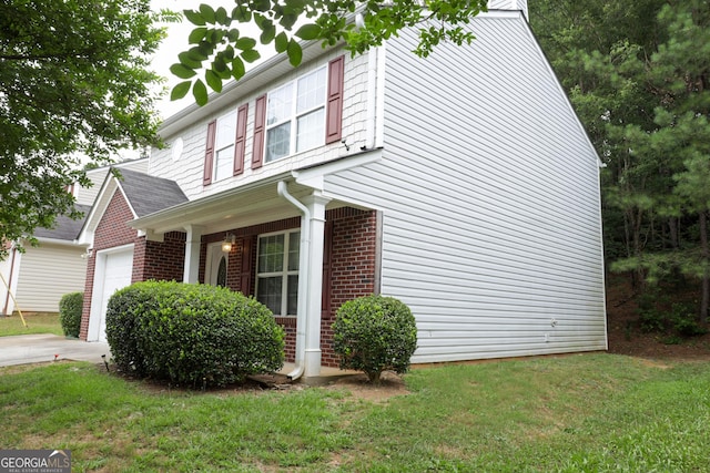 view of side of property featuring a garage and a lawn