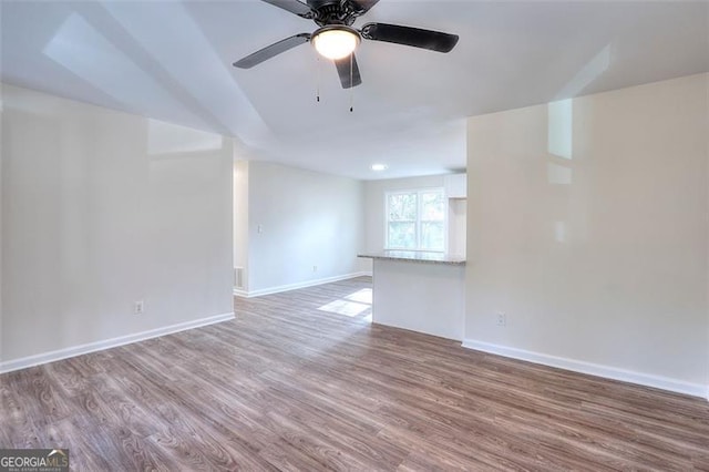 unfurnished living room featuring ceiling fan and wood-type flooring