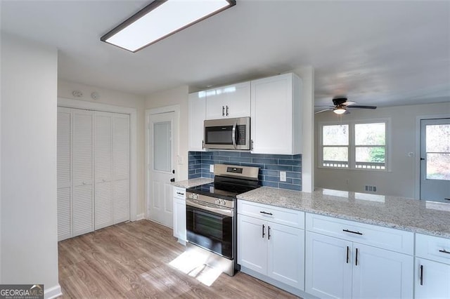 kitchen with white cabinetry, stainless steel appliances, and tasteful backsplash