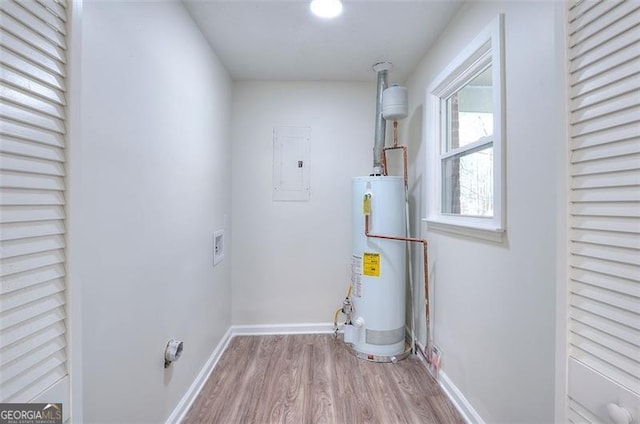 laundry room with wood-type flooring, washer hookup, electric panel, and water heater