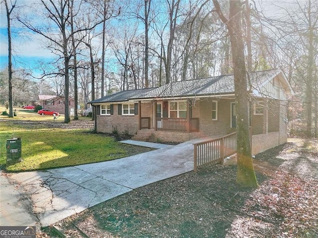 ranch-style home with covered porch and a front yard