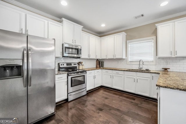 kitchen featuring appliances with stainless steel finishes, white cabinetry, and sink