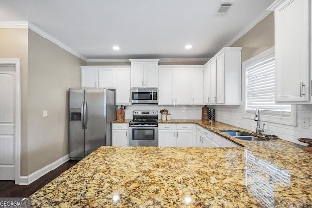 kitchen with decorative backsplash, white cabinetry, light stone counters, and appliances with stainless steel finishes