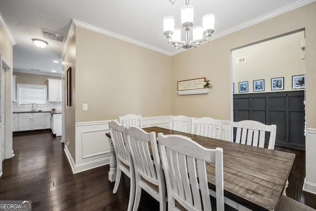 dining area with dark hardwood / wood-style flooring, ornamental molding, sink, and an inviting chandelier