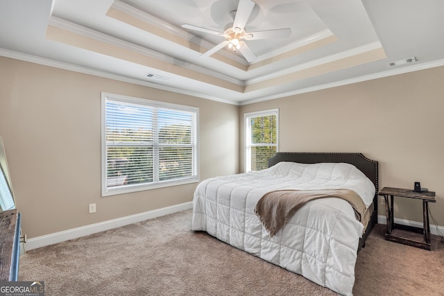 bedroom with ceiling fan, a raised ceiling, carpet floors, and crown molding