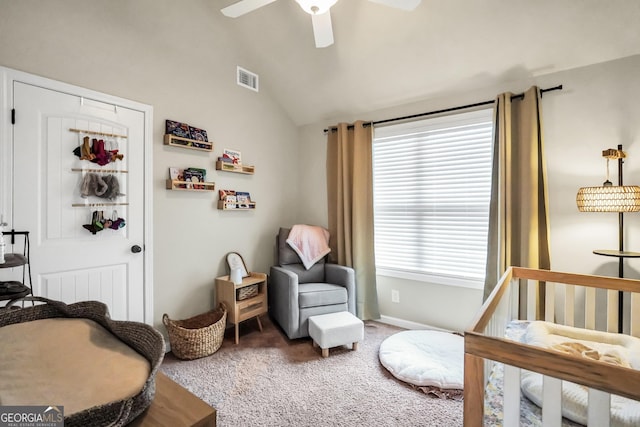 carpeted bedroom with ceiling fan, a nursery area, and lofted ceiling