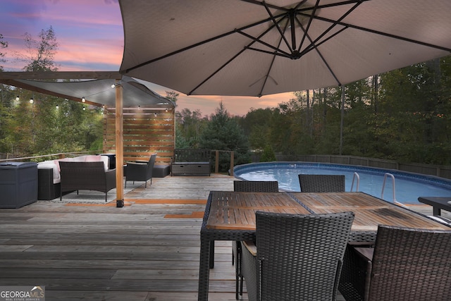 deck at dusk featuring an outdoor hangout area