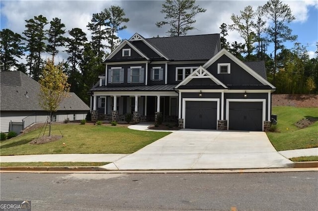 craftsman house with covered porch, a garage, and a front lawn