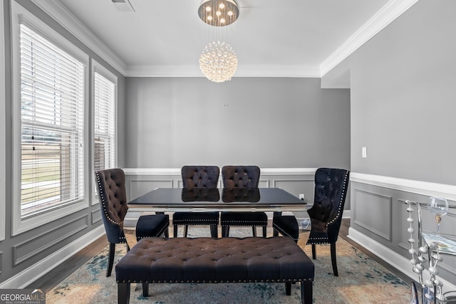 dining space featuring a wealth of natural light, crown molding, and an inviting chandelier