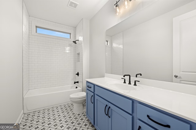 full bathroom featuring tiled shower / bath, vanity, and toilet