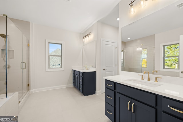 bathroom with vanity, a healthy amount of sunlight, and walk in shower