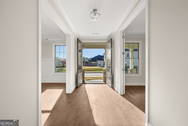 entrance foyer featuring crown molding and wood-type flooring