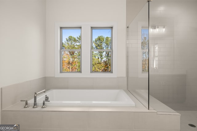 bathroom with a relaxing tiled tub