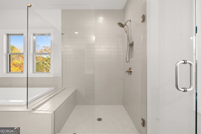 bathroom featuring shower with separate bathtub