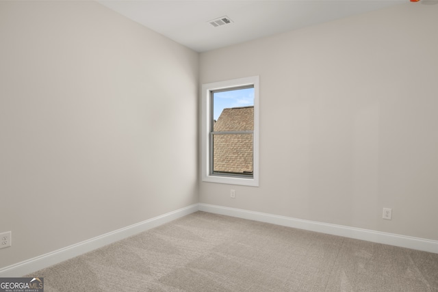 spare room featuring light colored carpet