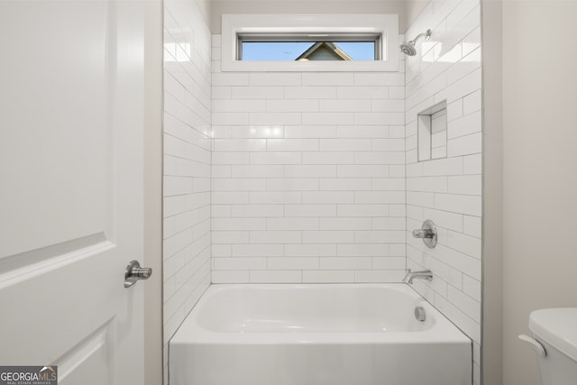 bathroom featuring tiled shower / bath and toilet