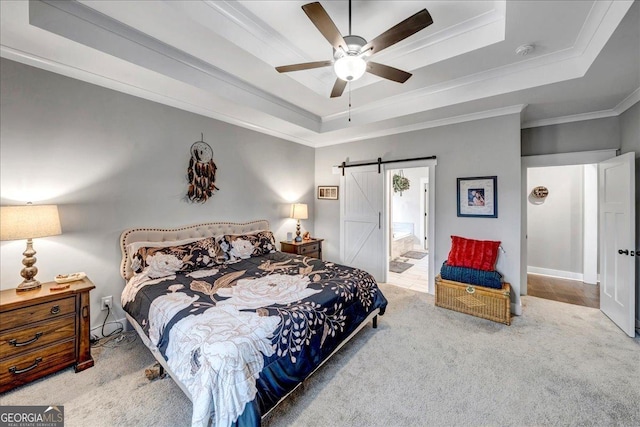 bedroom featuring a raised ceiling, a barn door, ceiling fan, and ornamental molding