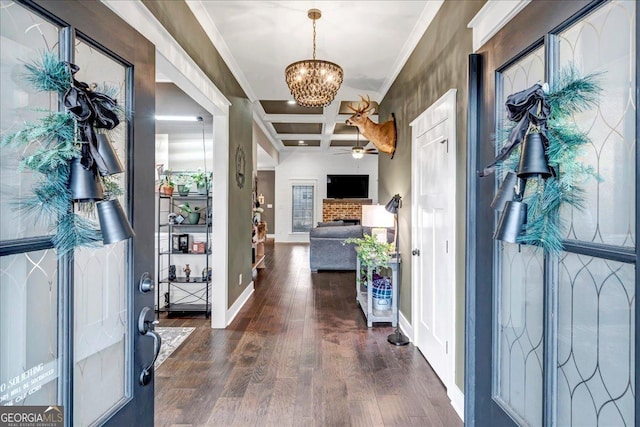 foyer with coffered ceiling, ceiling fan with notable chandelier, ornamental molding, beamed ceiling, and dark hardwood / wood-style flooring