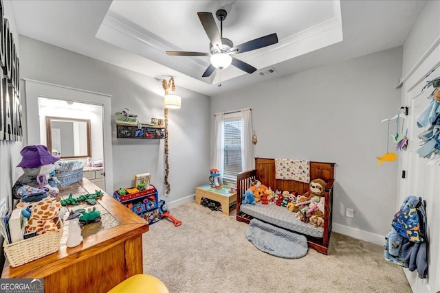 game room featuring carpet flooring, ceiling fan, and a tray ceiling