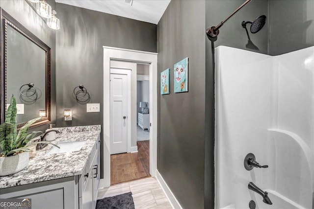 bathroom featuring hardwood / wood-style floors, vanity, and bathtub / shower combination